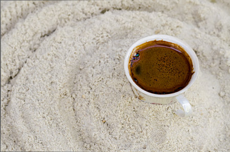 one cup with coffee costs on sandの写真素材
