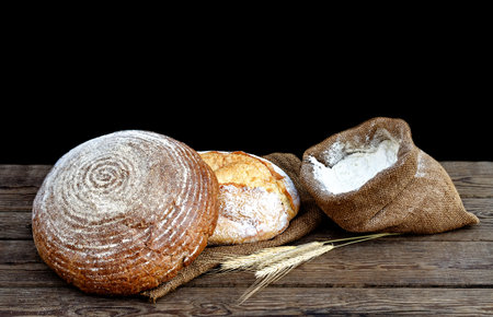 two bread and flour in a sack on a wooden table