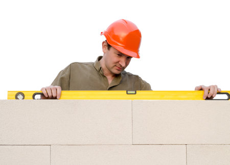 builder checks a level of a brick wall