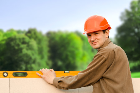Worker check the level of Brick wall construction for house building