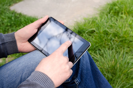 Man  using tablet pc in the parkの写真素材