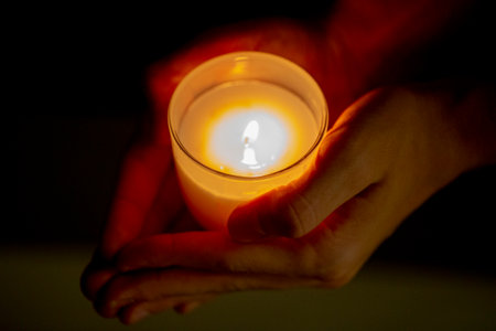 hand with a candle in the dark