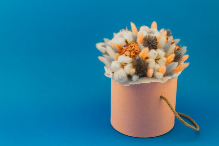 dried flowers in a bouquet, decoration on a blue background