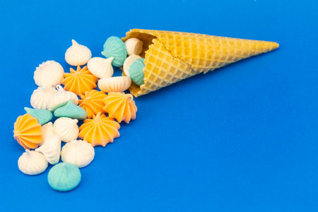 sweet marshmallows in waffles, spilled on a blue background. souffle in the form of ice creamの写真素材