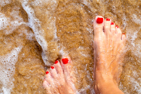 the texture of the beach, womens feet in the surfの写真素材