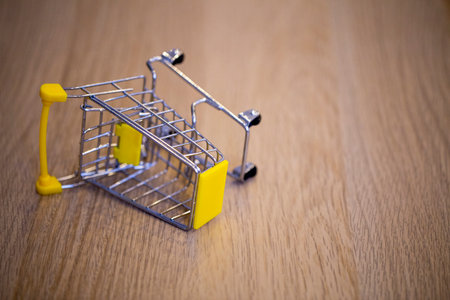 overturned grocery cart on the wooden surface of the tableの写真素材