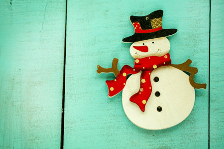 Christmas decorations snowman, red berries on wooden background close-up