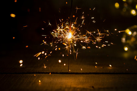burning Sparkler on a dark wooden background close-upの写真素材