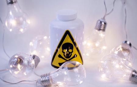 white bottle with the inscription Poison on the background of garlands of light bulbs close-upの写真素材