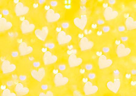 yellow background with bokeh of white foam hearts and light from a garland in partial blur, background of white heartsの写真素材