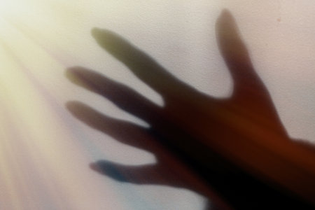 a blurred shadow of a hand on a painted wall, the shadow of a woman's hand close-up
