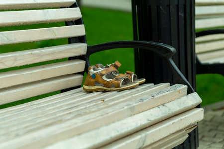 forgotten children's shoes on a park bench, close-upの写真素材