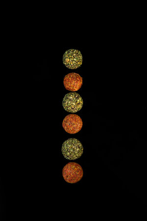 chocolate round candies sprinkled with spices on a dark background