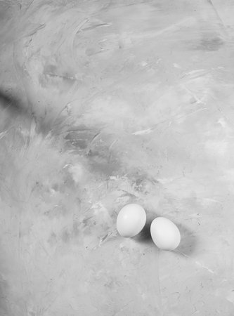 Chicken white eggs on a gray concrete background.の写真素材