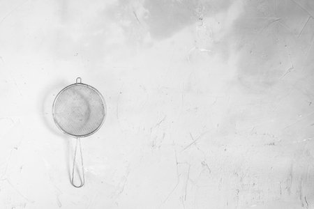Metal sieve on a gray concrete background.