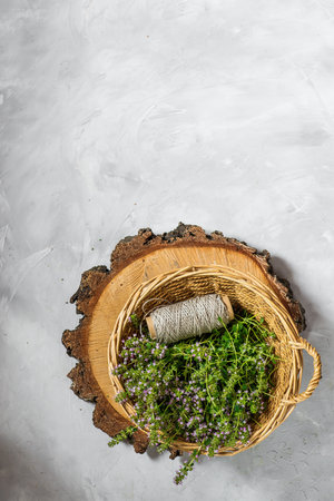 fresh thyme with fragrant flowers collected. on a gray background. in a wicker basket.の写真素材