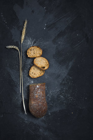 Freshly baked rye bread lies on a dark background.の写真素材
