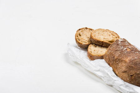 cut into slices of a loaf of dark bread made from rye flour lies
