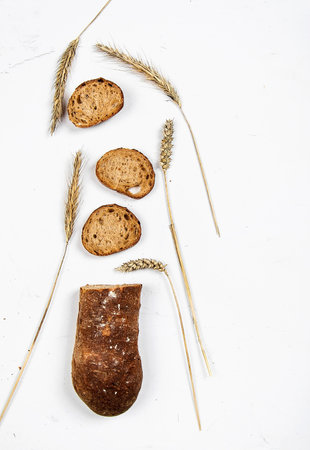 cut into slices of a loaf of dark bread made from rye flour lies