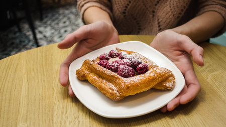 Girl holds dessert in the hands of a cafeの写真素材