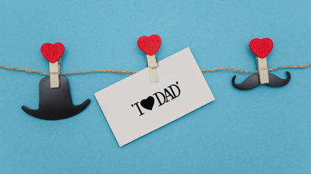 Concept for holiday father's day on a blue background. Clothespins on linen lace hold objects.の写真素材