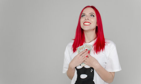 oyful girl with red hair on a white background. Girl with money