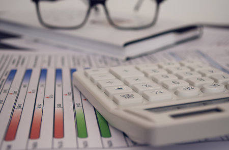 Calculator and pencil on color tables and graphs. Focus on the calculator. Financial concept.の写真素材