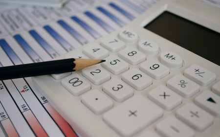 Calculator and pencil on color tables and graphs. Financial conceptの写真素材