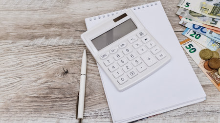 Workplace. Calculator, pen, notebook and money on the table. White backgroundの写真素材