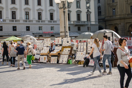 Florence, Italy - 22 April, 2018: street artist on Piazza della Repubblica selling artworks; tourists walking byのeditorial素材