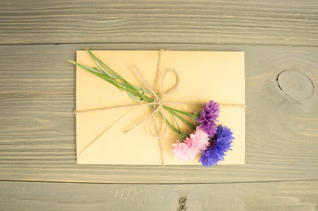 envelope with flowers cornflowers on wooden background