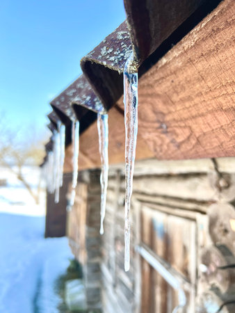 Icicles on the roof melt in the spring sun. Selective focusの写真素材