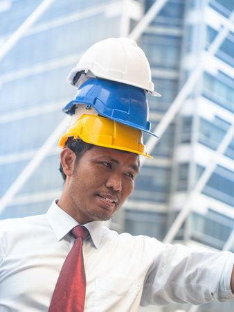 Portrait of a Powerful engineer with triple safety helmets. Engineer concept.