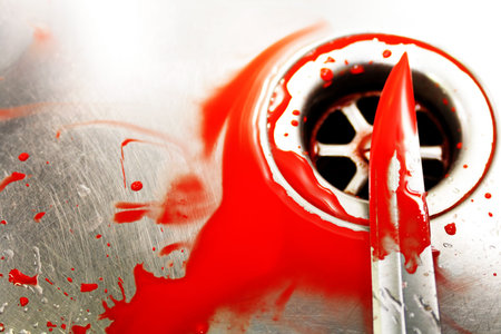 Illustrative styled image of a bloody knife over a plug hole in a stainles steel sink. Evocative of a murder scene, washing away the evidence.の写真素材