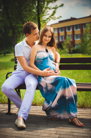 Happy pregnant Couple in the summer parkの写真素材