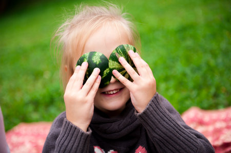 Family is eating a watermelon together in the park.の写真素材