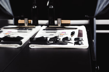 Young handsome barber making haircut, instruments in a barbershopの写真素材