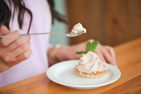 Woman eating a cake of cottage cheese in a ceramic plateの写真素材