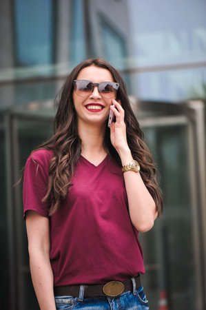 Portrait of young tourist in town using mobile phone