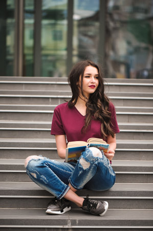 Young pretty woman sitting and reading a book enjoys of rest.の写真素材
