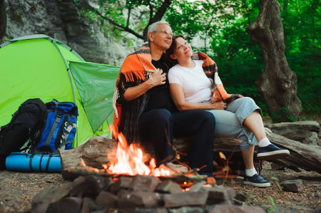 Tent camping couple romantic sitting by bonfire nightの写真素材
