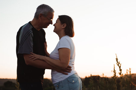 Couple holding hands at sunset enjoying romance and sunの写真素材