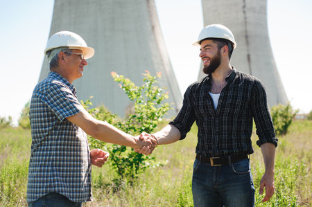 two power line tower workers with handshaking.