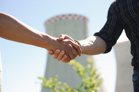 two power line tower workers with handshaking.の写真素材
