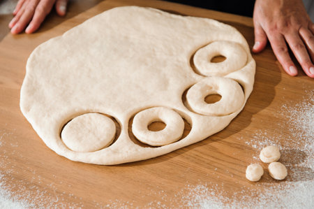 Chef preparing dough - cooking donuts process in the kitchen