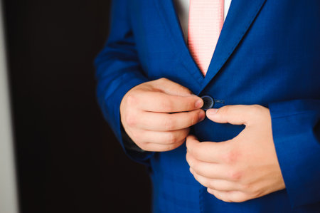 Young businessman puts a suit on before meeting with partners.