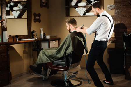 Master cuts hair and beard of men in the barbershopの写真素材