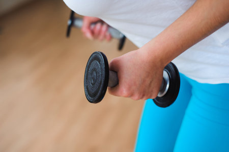 Fitness female woman with muscular body, doing her workout with dumbbells.の写真素材