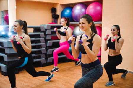 fitness, sport, training and lifestyle concept - group of happy women with dumbbells flexing muscles in gym.の写真素材