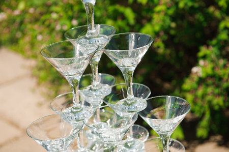 Pyramid of glasses of champagne. hill. Pyramid of champagne outdoors in the parkの写真素材